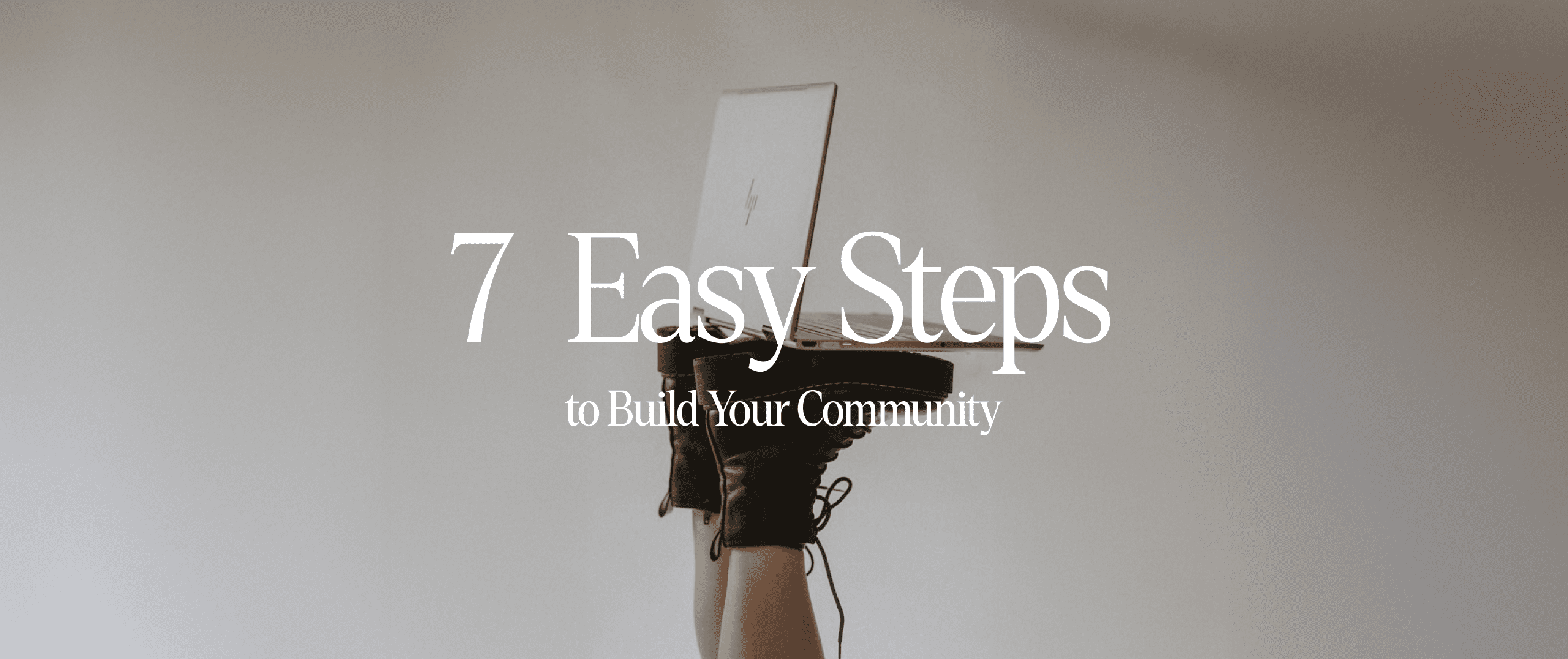 A person holding a laptop with their feet, displaying “7 Easy Steps to Build Your Community” — symbolizing creative and modern community-building strategies.