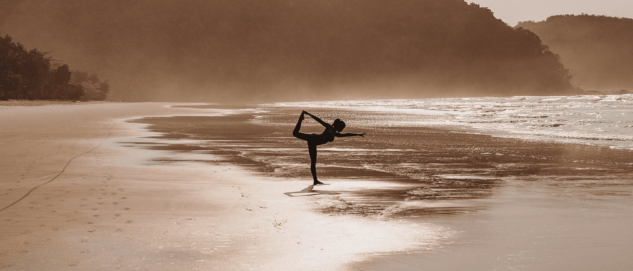 Person practicing yoga pose on a serene beach, embodying balance, resilience, and a growth mindset.