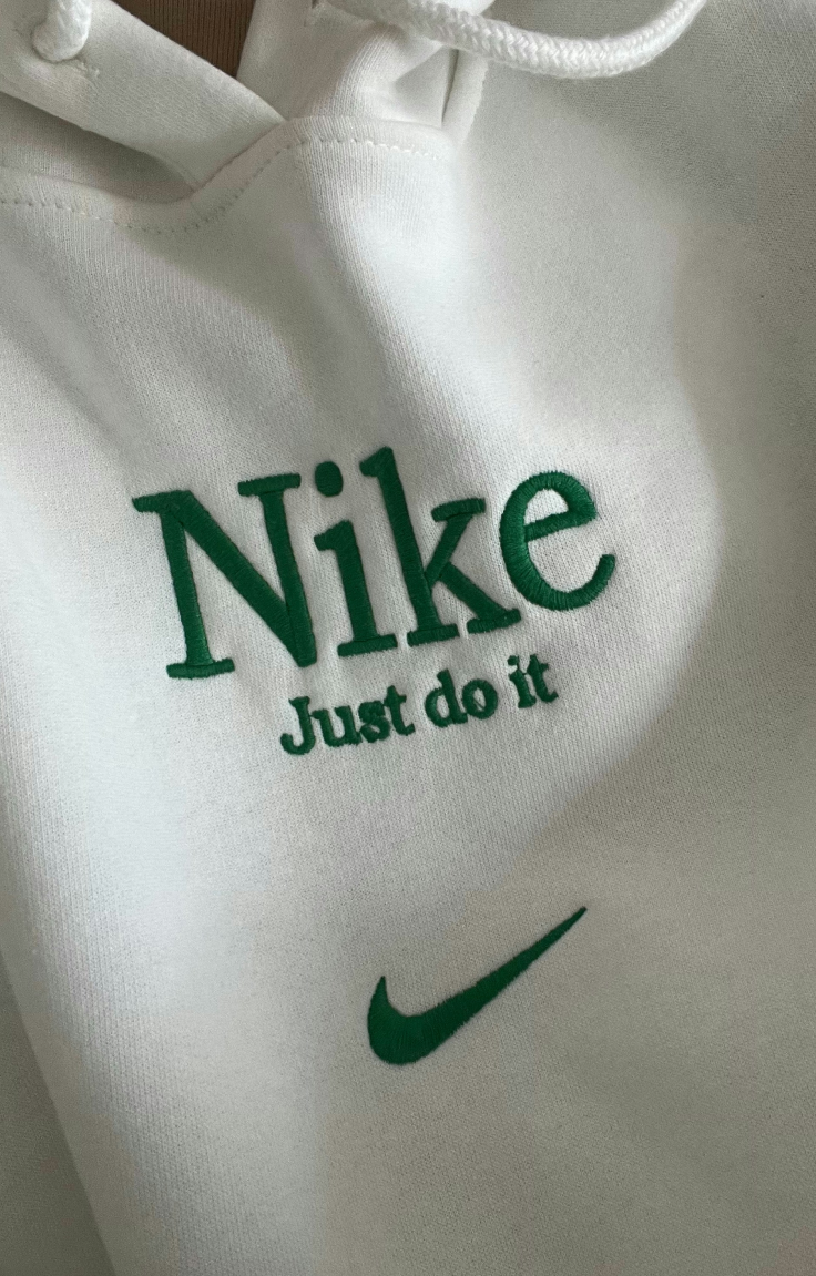 Nike logo with the “Just Do It” slogan embroidered on fabric, representing authenticity and community-driven brand engagement.