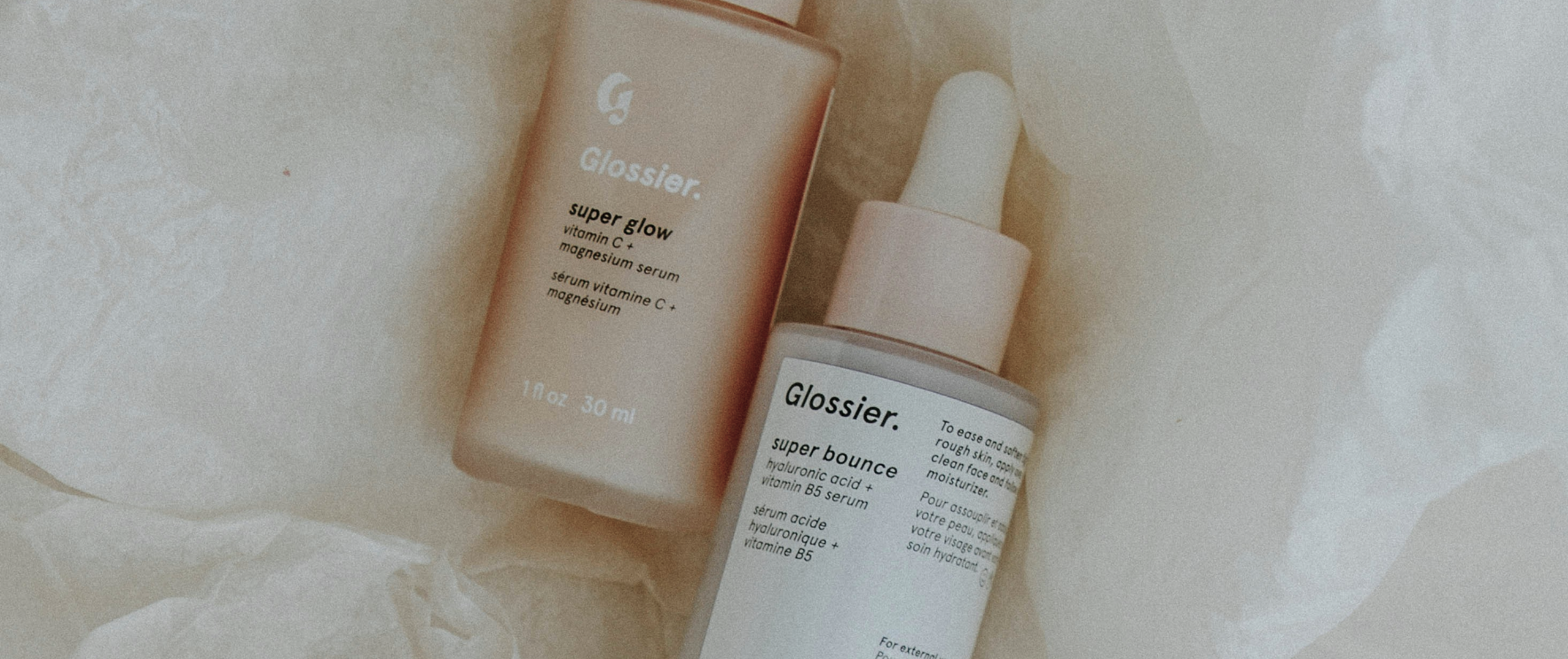 Glossier skincare products on a soft background, symbolizing user-driven beauty and community-focused brand development.