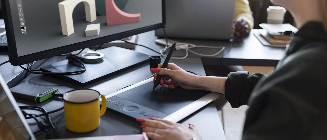Person drawing on a digital tablet at their desk, visualizing AI-driven brand identity design in 2025
