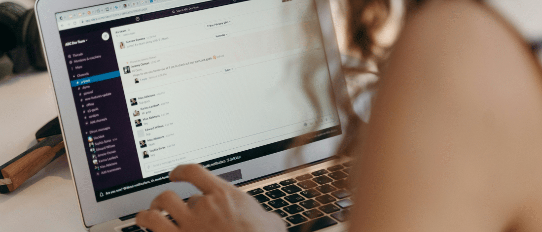 Person interacting with a team communication platform on a laptop, illustrating behind-the-scenes collaboration that supports user generated content (UGC) strategies.