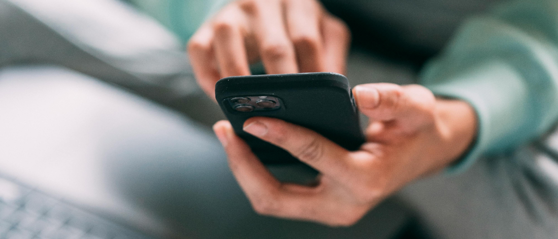 Close-up of hands holding a smartphone while typing — capturing real-time user interaction.